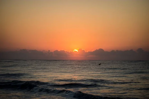オレンジ色の夕日の間に小さな波がある海の美しい景色 — ストック写真