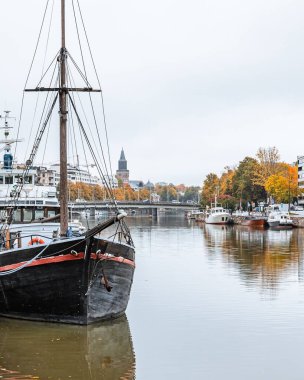 Aura nehri, sonbaharda Finlandiya 'nın Turku kentinde sonbahar yaprakları arasında gemilerle görülür.