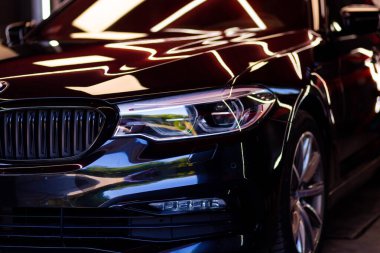 Siyah bir BMW aracının Uyarlamalı LED ışığının yakın çekim görüntüsü.
