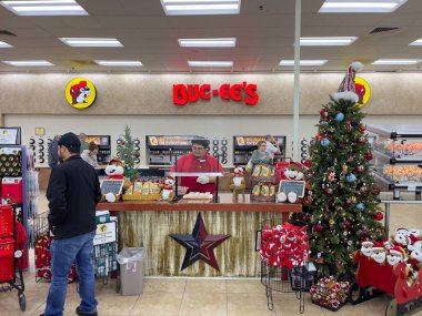 Texas City, TX, ABD - 18 Aralık 2022 - Buc-ee 'nin çalışanı Teksas' taki Buc-ee 's' de örnekler dağıtıyor