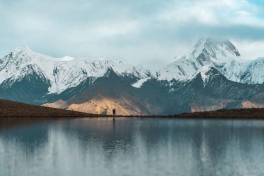 Karlı dağların manzarası bulutlarla kaplı.