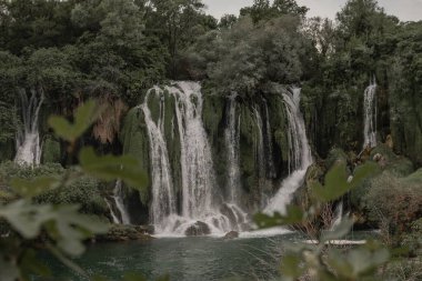 Ağaçlarla çevrili Kursunlu Şelalesi manzarası