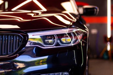 Siyah bir BMW aracının Uyarlamalı LED ışığının yakın çekim görüntüsü.