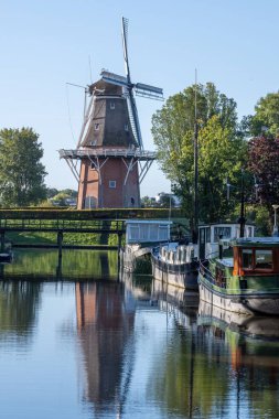 Sumar 'da mavi gökyüzünün önündeki eski bir yel değirmeninin dikey görüntüsü.