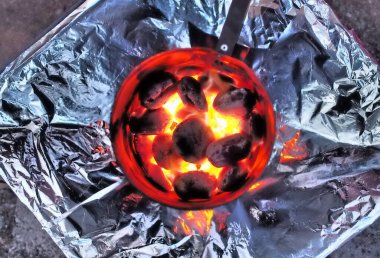 Kamp ateşi yakmaya hazırlanırken yanan ve parlayan kömürün en üst görüntüsü.