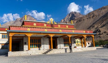 Tabo Manastırı 'nın önünde dua eden bir adam. Tabo, Himachal Pradesh, Hindistan' da, güneşli bir günde, arka planda bir dağ ile.