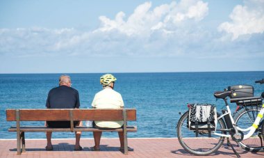 Denize bakan bir bankta oturan olgun bir çiftin güzel bir fotoğrafı.