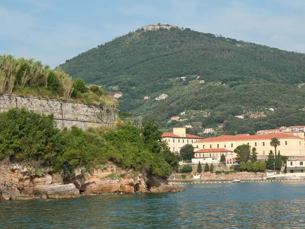 意大利斯皮西亚的绿色海岸 有石头建筑 水边青山 蓝蓝的天空 — 图库照片