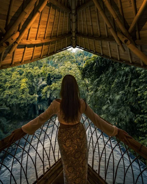Pionowe Ujęcie Samicy Pozującej Płocie Balkonie Drewnianym Dachem Naturą Tle — Zdjęcie stockowe
