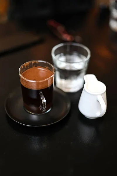 Een Zwarte Tafel Met Een Kop Koffie Een Portie Melk — Stockfoto