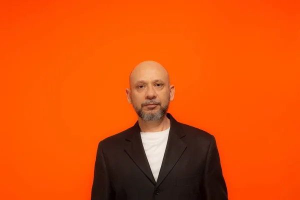 Πορτρέτο Ενός Κομψού Επιχειρηματία Που Κοιτάζει Την Κάμερα Απομονωμένα Πορτοκαλί — Φωτογραφία Αρχείου