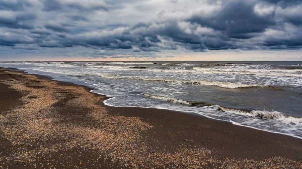 一张美丽的海滨照片 在戏剧化的天空下荡漾着海浪 — 图库照片