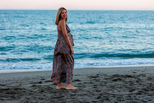 一个年轻快乐的怀孕女性穿着裙子在海滨摆姿势 — 图库照片