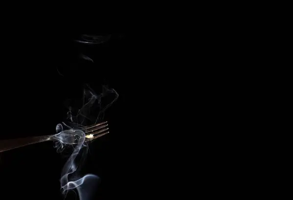 黒い背景に煙と銀のフォーク — ストック写真