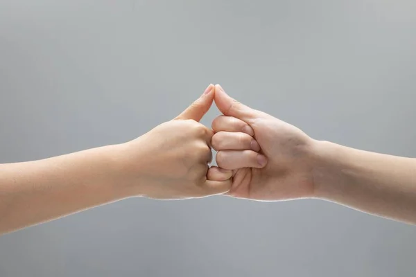 Nahaufnahme Zweier Helfender Hände Die Sich Vor Grauem Hintergrund Berühren — Stockfoto