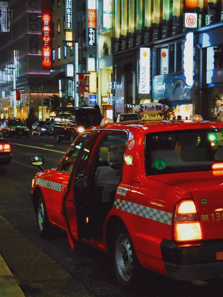 Taksówka Zatrzymująca Się Dla Klienta Podczas Pracowitego Nocnego Życia Dzielnicy — Zdjęcie stockowe