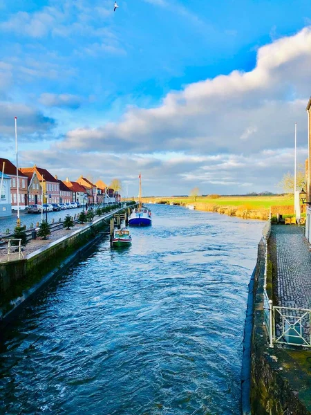 丹麦一个河边小镇上的一座五颜六色的房子旁边停着一艘船的垂直照片 — 图库照片