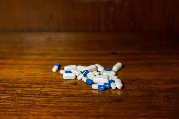 Een Close Van Witte Blauwe Pillen Medicijnen Bruine Achtergrond — Stockfoto