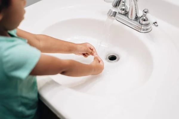 stock image A cute preschool girl practicing good hygiene using the bathroom sink as she washes up