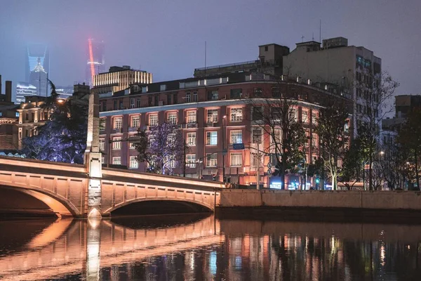 Міський Пейзаж Мостом Прибережними Будівлями Відображають Воду Вночі — стокове фото
