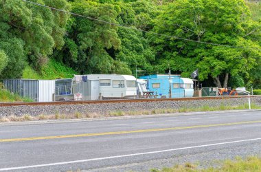 Yeni Zelanda 'da yol ve demiryolu kenarındaki bir kamp yerine park etmiş bir grup karavan.