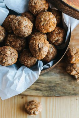 Yulaf ezmeli kurabiyenin dikey yakın çekimi tahtanın üzerindeki kahverengi kutuda ısırır.