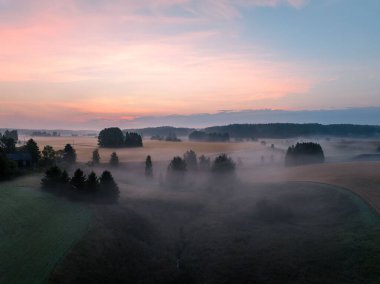Gün batımında sisli bir günde büyük manzaraların hava görüntüsü.