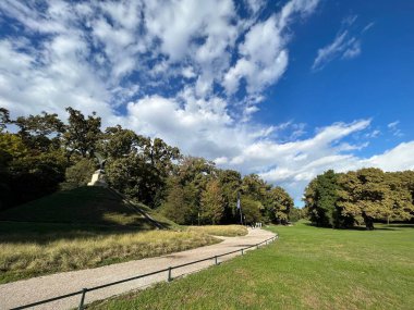 Güneşli bir günde yeşil parkın içinden geçen güzel bir manzara.