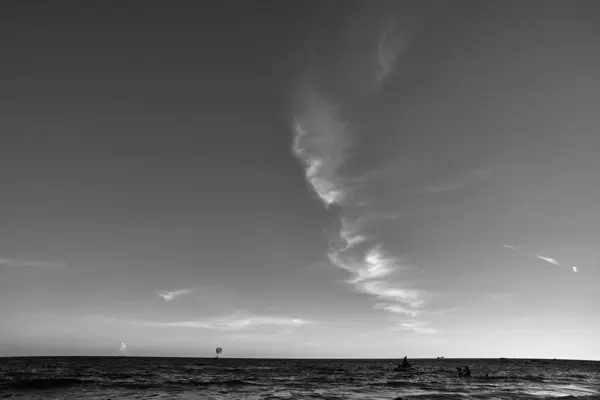 在万里无云的天空中 茫茫大海中的一群遥远的人 — 图库照片