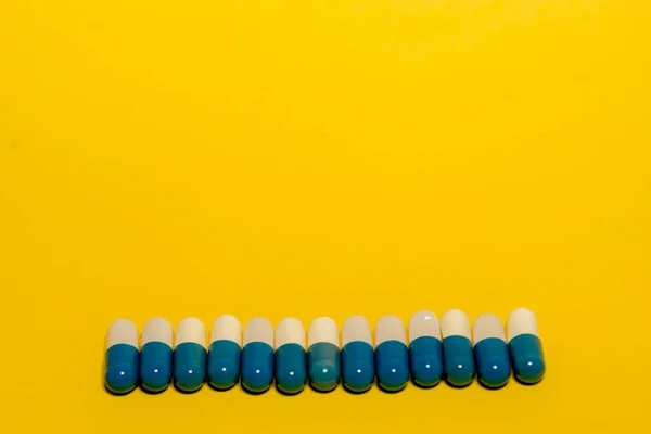 白と青の錠剤と黄色の背景の薬の閉鎖 — ストック写真