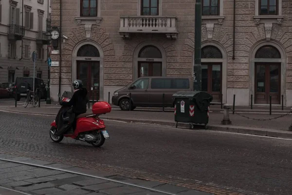 冬にトリノの狭いタイル張りの通りに赤いモップに乗っている男 — ストック写真