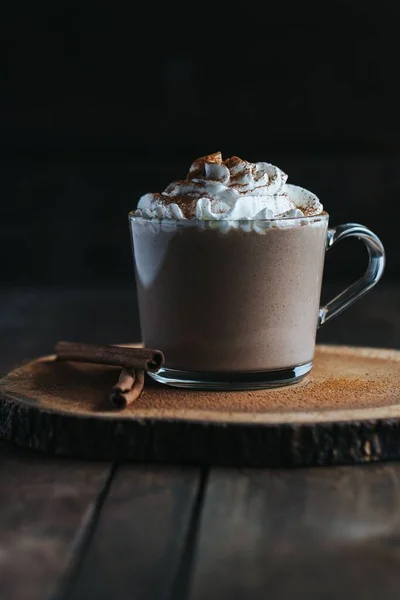 Tahta Üzerinde Krema Olan Bir Bardak Sıcak Çikolatanın Dikey Yakın — Stok fotoğraf