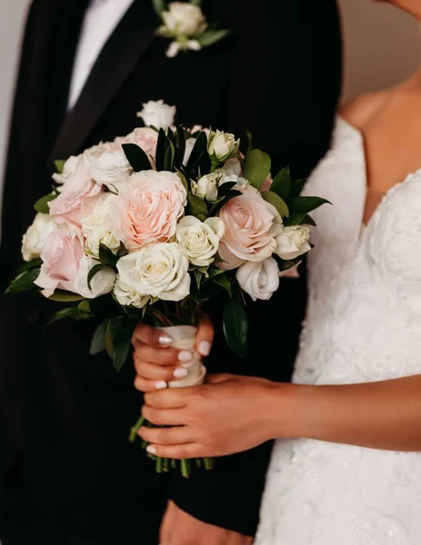 花嫁と新郎の垂直ショットは繊細な結婚式の花束を保持 — ストック写真