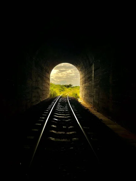 外から光が差し込む暗いトンネル内の鉄道 — ストック写真