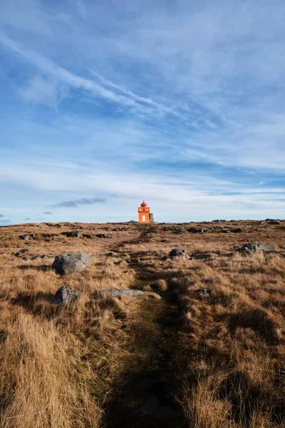 アイスランドの野原の赤い灯台の垂直方向の遠望 — ストック写真