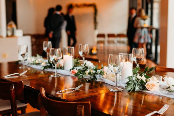 背景がぼやけている人々との結婚式のためのキャンドルや花束で飾られたテーブル — ストック写真