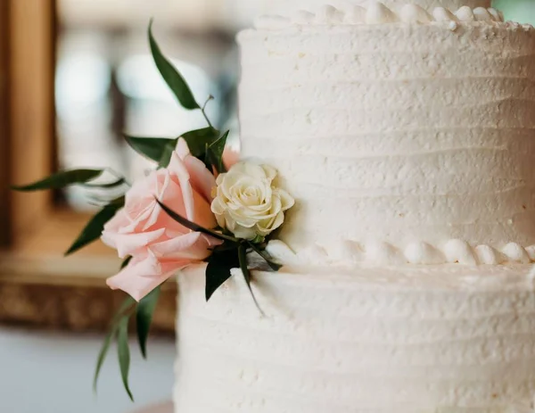 結婚式のために用意された花で飾られた美しい白いウェディングケーキ — ストック写真