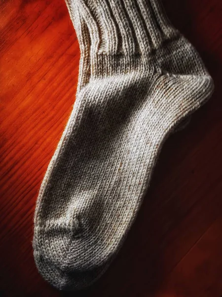 Μια Λευκή Ζεστή Μάλλινη Κάλτσα Για Κρύο Χειμώνα Κόκκινο Ύφασμα — Φωτογραφία Αρχείου