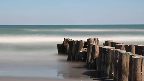 木の柱で海とビーチの長い露出 — ストック写真