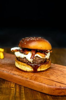 Siyah arka planda izole edilmiş tahta üzerinde karışık çizburger sandviçi.