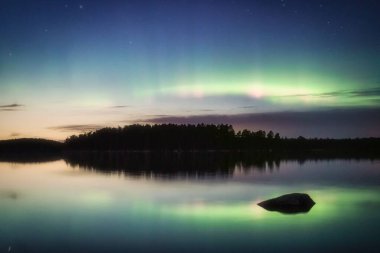 Finlandiya, Poytya 'daki bir gölün üzerindeki kuzey ışıklarının ya da Aurora Borealis' in nefes kesici manzarası