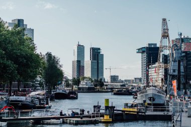 Rotterdam 'ın deniz bölgesinin şehir manzarası. Hollanda' daki şehir binalarına karşı gemiler var.