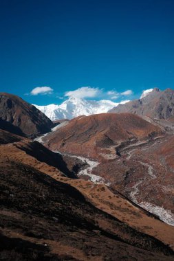 Nepal 'deki mavi gökyüzü arka planında Everest Dağı' nın dikey manzarası