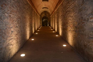 Yerdeki ışıklarla aydınlatılmış uzun, karanlık bir koridor.