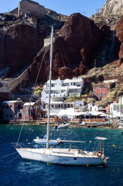 A vertical shot of yachts and boats on Santorini Island on a sunny summer day clipart