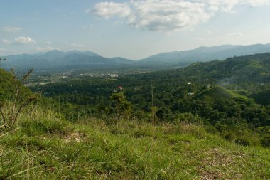Güneşli bir günde görülen vadiler ve dağlarla dolu güzel bir manzaranın manzarası.