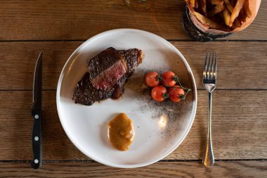 Çeri domatesli lezzetli bir bifteğin üst görüntüsü.