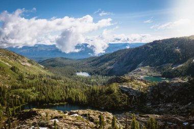 Yoğun ağaçlarla çevrili dağ manzarası.