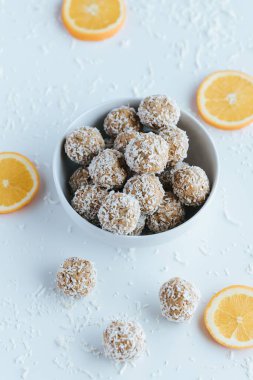 Beyaz arka planda hindistan cevizi ısırığı ve portakallarının dikey görüntüsü