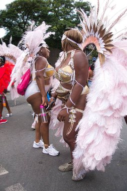 İngiltere 'de Notting Hill Karnavalı 2022' ye renkli kostümlerle katılan bir grup insan.